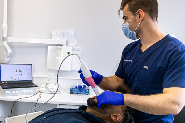 Dr Ben Gregory is scanning a patient's teeth in preparation for clear aligners.